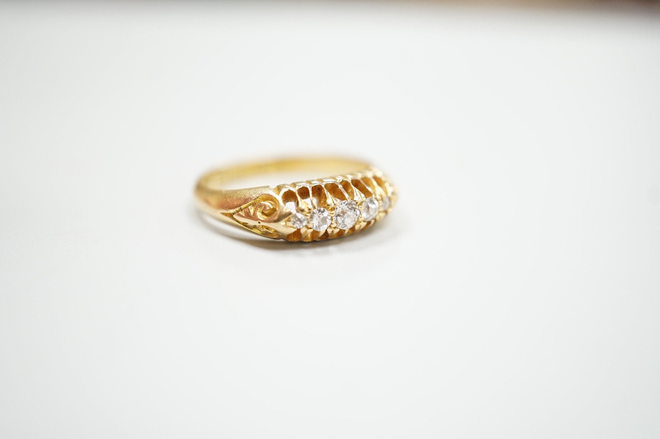 An early 20th century 18ct gold and graduated five stone diamond chip set ring, size L, gross weight 3.6 grams.